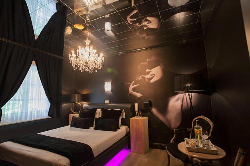 um quarto com uma cama e um candelabro e um quarto com uma cama em Villa Valentino em Hasselt