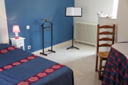 een blauwe kamer met 2 bedden en een stoel bij La chambre du harpiste in Saint-Mars-la-Jaille