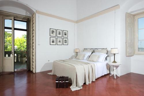 a white bedroom with a bed with white sheets and pillows at Castello di Casamassella - Marea Stays Collection in Casamassella