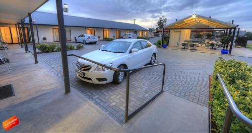 a white car parked in front of a house at Red Earth Motel in Broken Hill