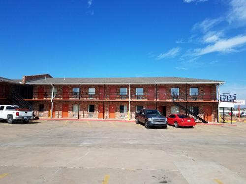 un edificio con dos coches estacionados en un estacionamiento en Heritage Inn, en Duncan