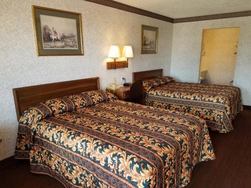 Habitación de hotel con 2 camas y 2 lámparas en Heritage Inn, en Duncan