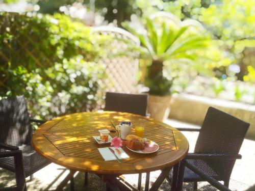 een houten tafel met een bord eten erop bij Hotel Alexandre III in Cannes