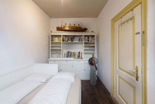 Habitación con 2 camas blancas y estante para libros. en Juttershoek, en Kampen