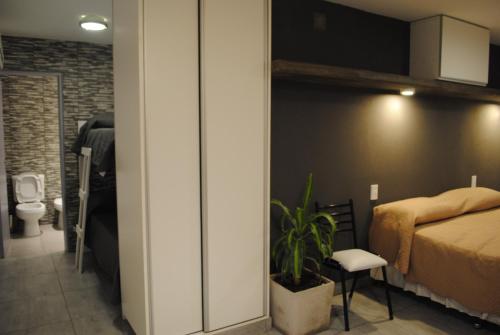 Habitación pequeña con cama y baño. en Darwin Apart Hotel en Salta