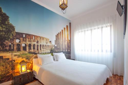 um quarto com uma cama branca e uma pintura do Coliseu em Furadouro Terrace Hostel no Furadouro