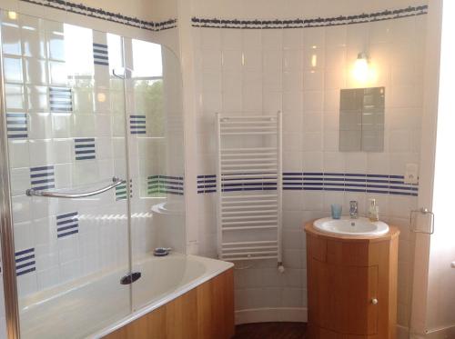 a bathroom with a tub shower and a sink at Château de La Ville-Huë in Guer
