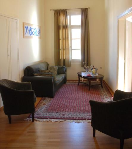 a living room with a couch and a table at Allotino Pension in Nafplio