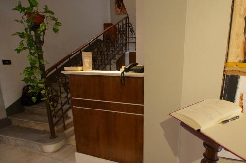a hallway with a staircase with a sink and a book at Alkimia Smart Rooms in Ferrara