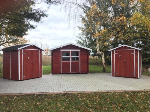 two red storage sheds sitting in a parking lot at Haus Hugo Zingst in Zingst