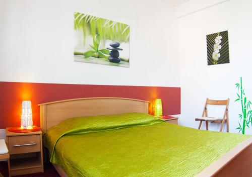 una camera con un letto verde con due lampade di Apartamenty Lila a Cracovia