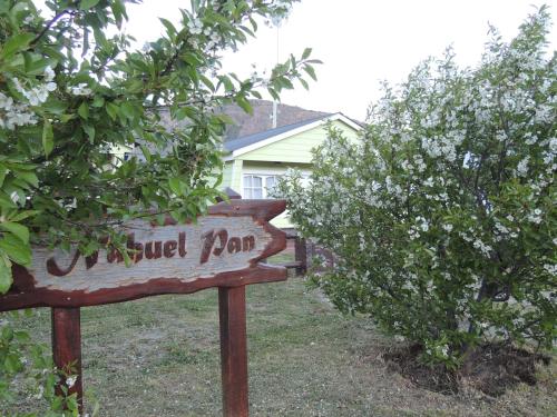 a sign in front of a house with a bush at Complejo "Nahuel Pan " in El Chalten