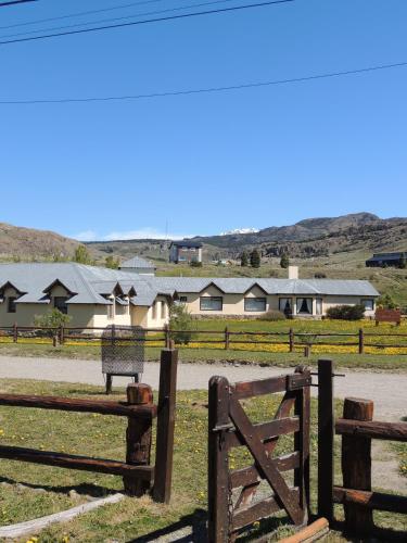 a fence in a field with houses in the background at Complejo "Nahuel Pan " in El Chalten