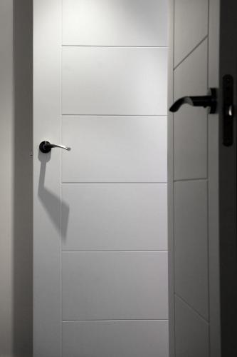 a white door with a handle in a room at Laila Home in Barbastro