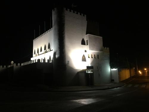 a large white building with lights on it at night at El Castillo in Alcalá de Guadaira
