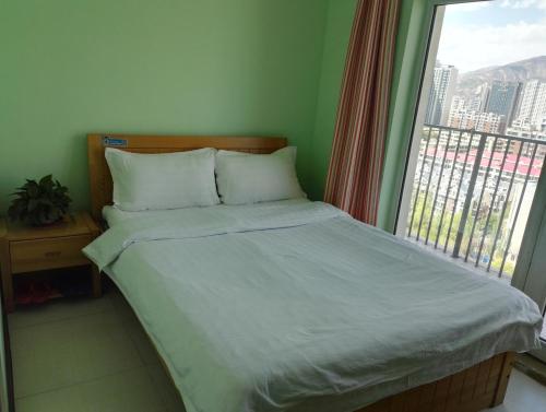 a bed in a room with a large window at LETE Hostel in Xining