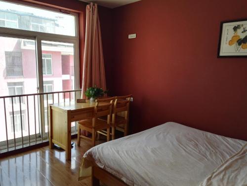 a bedroom with a desk and a bed and a window at LETE Hostel in Xining