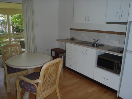 a kitchen with a table and chairs and a sink at Beachside Holiday Units in Bowen