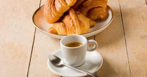 a cup of coffee and a plate of bread at Nuevo Horizonte in Pasto