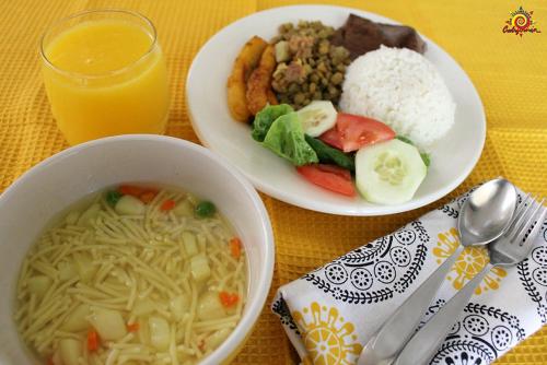 a table with two plates of food and a bowl of soup at Nuevo Horizonte in Pasto