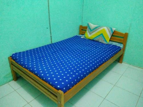 un letto in una camera con parete blu di Crystall Guesthouse a Banda Aceh