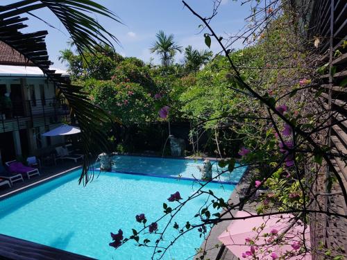 a swimming pool in the middle of a garden at Sanur Agung Hotel in Sanur