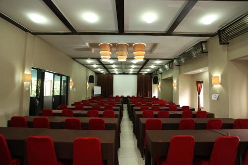 a large room with red chairs and tables and lights at Sanur Agung Hotel in Sanur