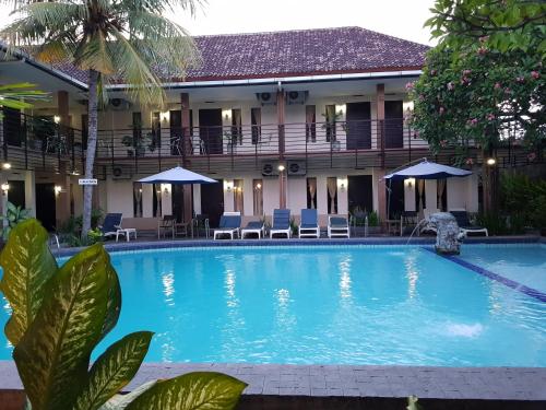 a large swimming pool in front of a building at Sanur Agung Hotel in Sanur