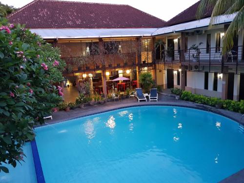 a large blue swimming pool in front of a building at Sanur Agung Hotel in Sanur