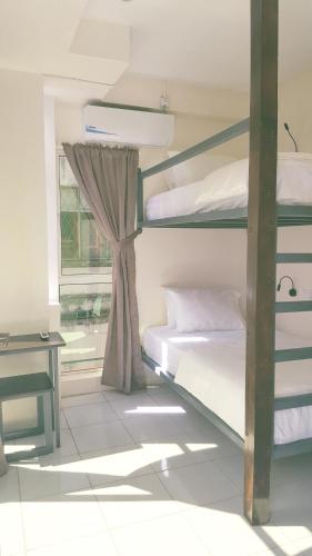 a bedroom with two bunk beds and a window at Kuree Hut in Semporna