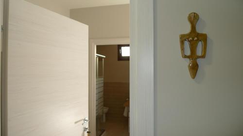 a hallway with a white wall and a light fixture at B&B Casa Olla in Sardara