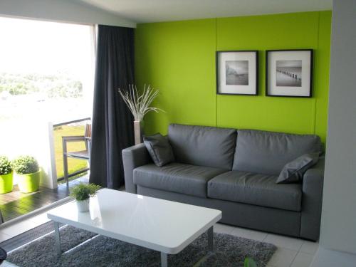 ein Wohnzimmer mit einem Sofa und einem Tisch in der Unterkunft Appartement Iris in De Haan