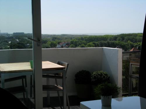 a balcony with a table and chairs and a view at Appartement Iris in De Haan