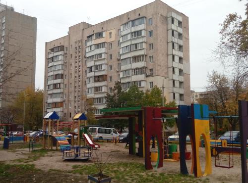 une aire de jeux en face d'un grand bâtiment dans l'établissement Apartment on Kharkovskoe Shosse 170 b, à Kiev