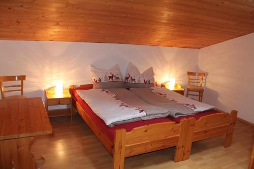 a bed in a room with two tables and two lamps at Apartment Sagtaler Spitze in Alpbach