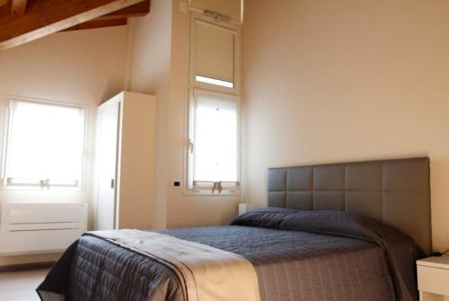 sypialnia z łóżkiem i 2 oknami w obiekcie Agriturismo Zapparè Farm Hotel w mieście Trevignano