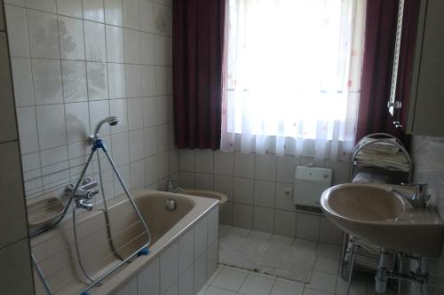 a bathroom with a tub and a sink at Ferienwohnung Ebner in Flattach
