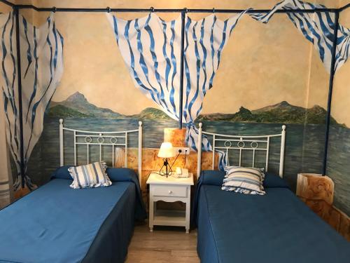sypialnia z 2 łóżkami i obrazem na ścianie w obiekcie Hotel Las Rosas w mieście Priego de Córdoba