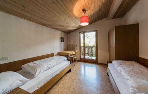 two beds in a room with a table and a window at Residence Trametsch in Bressanone