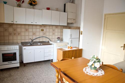 a kitchen with white cabinets and a wooden table at Silvio in Massa Marittima