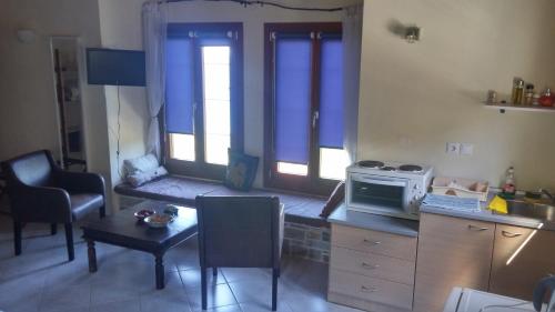 uma pequena cozinha com uma mesa e um micro-ondas em Orly's Villas em Chorefto