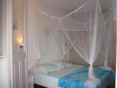un dormitorio con una cama con dosel en LeLagon Vue Mer, Pieds dans l'eau, en Saint-François