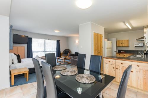 a kitchen and dining room with a table and chairs at Dolphin Motel in Paihia