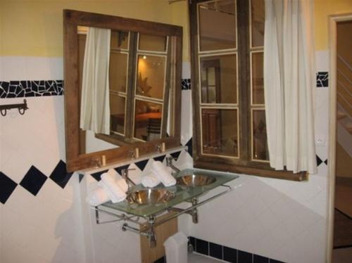 a bathroom with two sinks and a mirror at Logis Hotel La Grange Du Relais in Colombey-les-deux-Églises