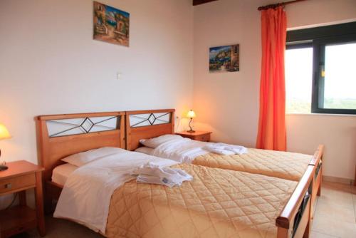 フランゴカステッロにあるTheo Beach Villaのベッド2台、ベッドルーム(ランプ2つ、窓付)