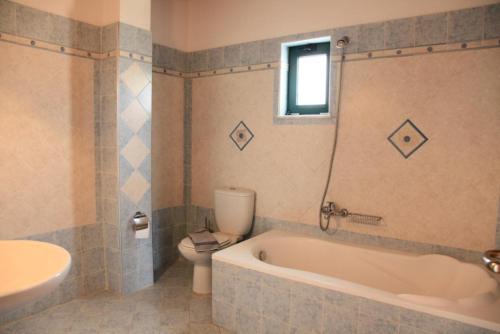 フランゴカステッロにあるTheo Beach Villaのバスルーム(バスタブ、トイレ、シンク付)