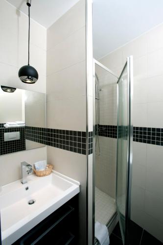 une salle de bain blanche avec un lavabo et une douche dans l'établissement Appartement Censier Daubenton, à Paris