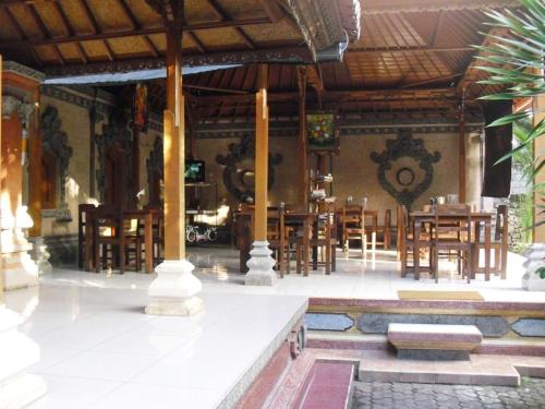 a room with tables and chairs in a building at Adus Beach Inn in Legian