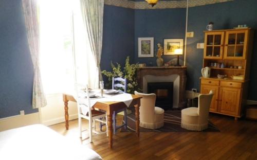 a dining room with a table and chairs and a fireplace at La Grange en Champagne in Hermonville