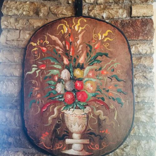 a painting of a vase of fruit on a wall at Tritoxo Guesthouse in Koukouli
